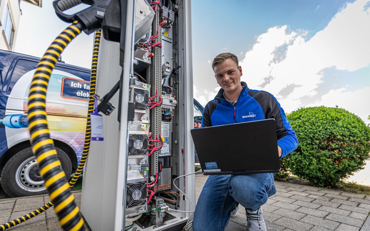 Techniker von Elektro Weber an einer Ladesäule mit Laptop